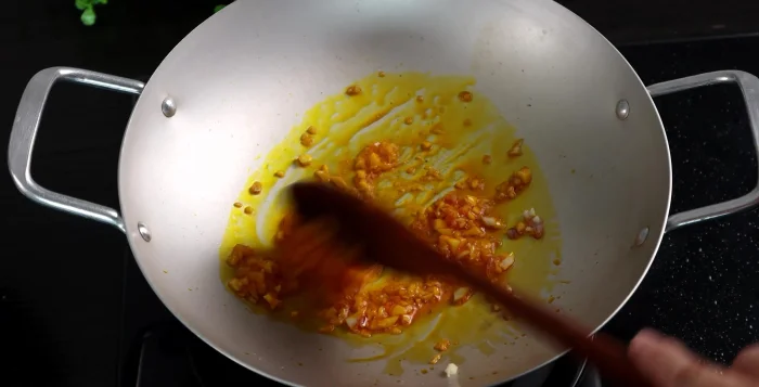 Heat annatto oil (or regular cooking oil) in a pan, then sauté onions and garlic until fragrant.