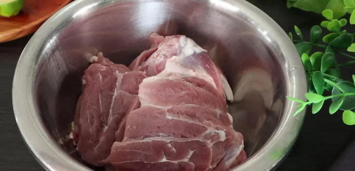 Cut half a lemon and squeeze the juice over the pork leg. Add half a tablespoon of salt. Massage the lemon juice and salt into the meat thoroughly to clean and remove any fishy smell. Let it sit for about 3 minutes, then rinse again.