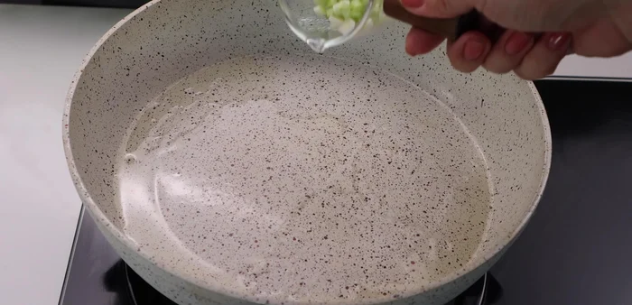 In the same pan, sauté the green onion roots until fragrant.