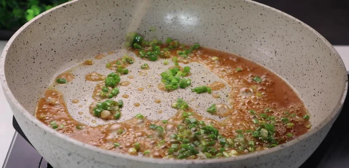 Add the remaining green onions and the fried rice to the pan. Stir well to coat the rice with the sauce. Turn off the heat and continue stirring to allow the flavors to meld.