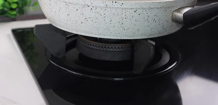 Heat cooking oil in a pan. Test the oil temperature by adding a small amount of rice; it should puff up when the oil is hot.