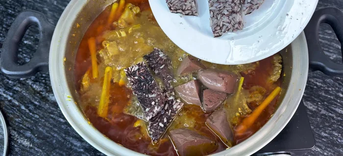 Add the fried potatoes, coconut milk, fresh milk, and (optional) sticky rice blood. Stir gently and bring to a boil.