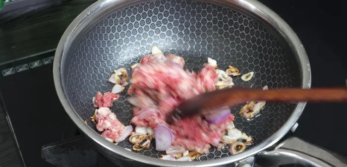 Add the marinated beef to the pan and stir-fry until firm.