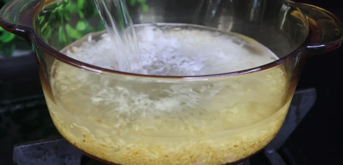 Add 1.5 liters of water to the roasted rice and cook until the porridge softens.