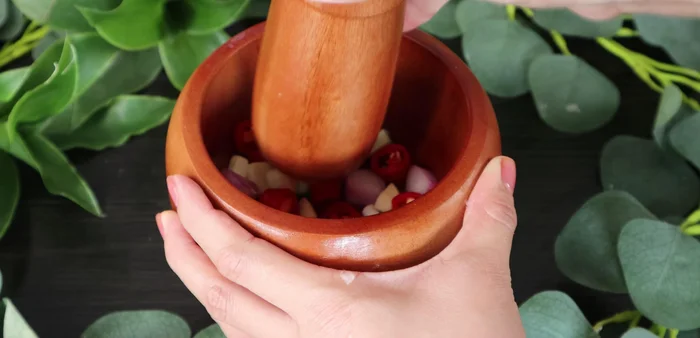 Pound onions, garlic, and chili in a mortar. Mix with sugar, MSG, and fish sauce to make a paste.