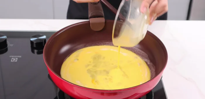 Cook the egg mixture in the pan until set.