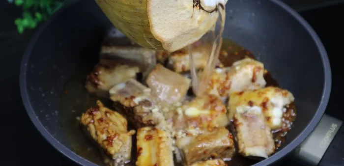 Add 200ml of coconut water (or filtered water). Bring to a boil, then lower heat and simmer, turning the ribs occasionally.