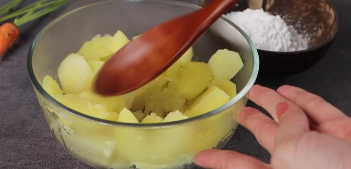 Mash the hot potatoes until smooth.