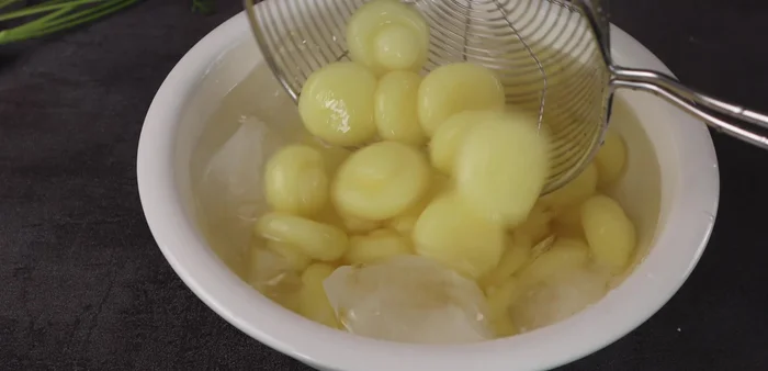Immediately transfer the cooked potato balls to a bowl of ice water to prevent them from becoming mushy and maintain a soft, chewy texture. Soak for about 5 minutes.