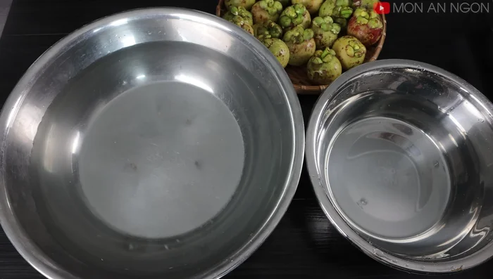 Prepare two basins of water. In a smaller basin, mix 2 liters of water, 3 lemons, and 2 tablespoons of salt. This is to soak the mangosteens to prevent browning.