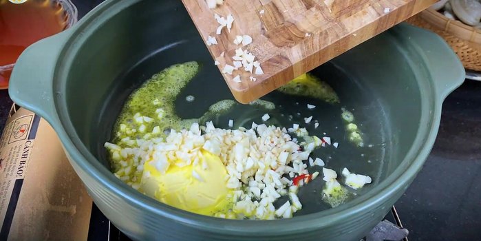 Melt butter in a pot, add minced garlic and chopped chili peppers until fragrant.