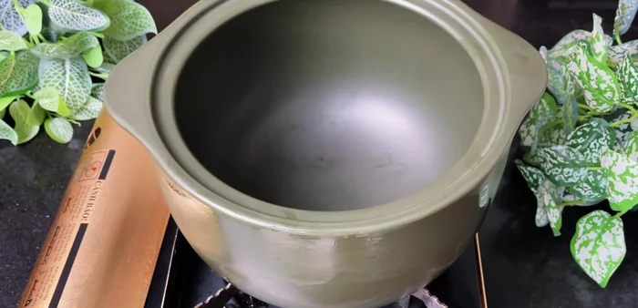 Prepare the hot pot broth: heat oil in a Minh Long ceramic pot, sauté lemongrass, ginger, garlic, and onion until fragrant. Add pineapple and tomatoes, stir-fry until slightly softened.