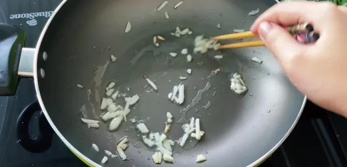 Stir-fry the bamboo shoots with garlic, sugar, and fish sauce until fragrant. Add onion and chili pepper, then coriander.