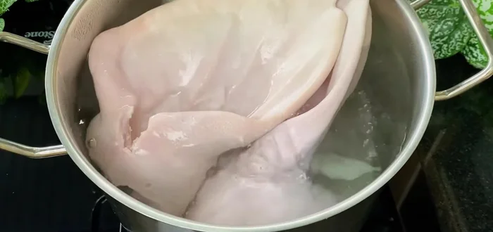 Boil the pig ears: In a separate pot, boil the pig ears with water, salt, and half an onion for 20-25 minutes until cooked. (258.479)