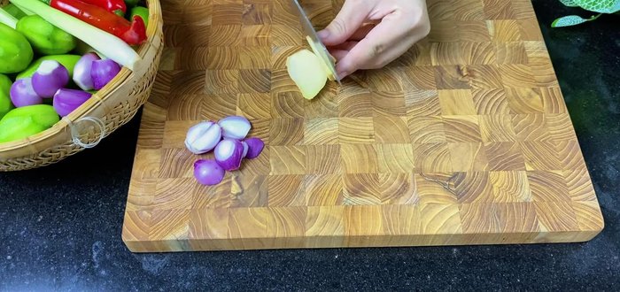 Prepare the aromatics: Finely chop onions, ginger, chili peppers, star fruit, and slice lemongrass. (282.919)
