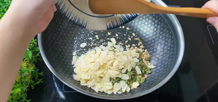 Combine roasted seeds with the sauce, simmering over low heat until fragrant. Add walnuts and cook until fragrant.