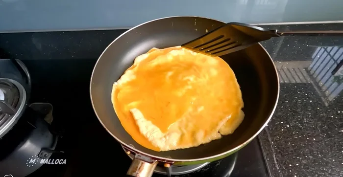 Prepare the egg topping: Whisk eggs and fry in a thin layer. Let cool and cut into strips.