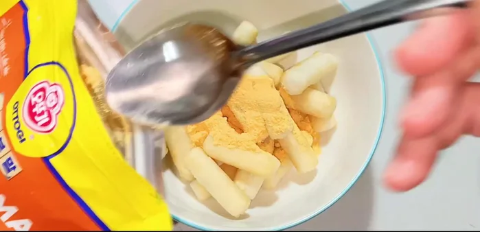 Add 1-1.5 tablespoons of Mai powder (powdered sugar). Cover and shake well to coat the rice cakes evenly.