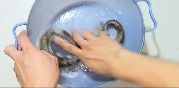 Clean the eel: Rinse briefly, then add salt and rub to remove slime. Rinse again with water, removing blood along the eel's spine. Repeat the salt-rubbing and rinsing process if necessary. Add vinegar for extra cleaning.