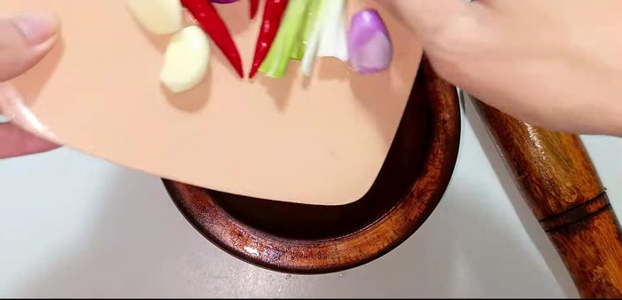 Pound garlic, shallots, chili peppers in a mortar to make a paste.