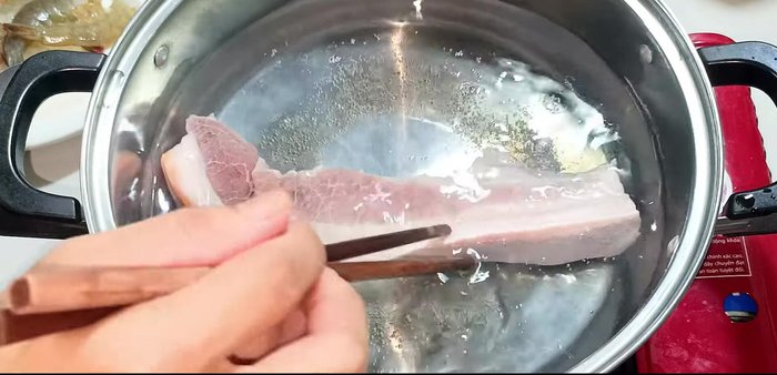 Boil the pork in water for 15 minutes. Meanwhile, prepare the fish sauce for the salad: 3 tablespoons sugar, 5 tablespoons fish sauce, 2 tablespoons lemon juice, and a spoonful of chili sauce.