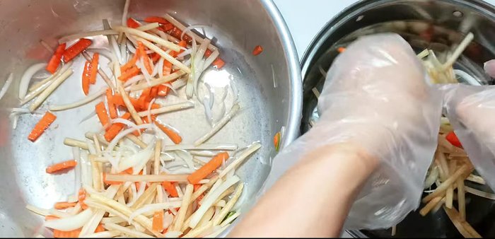Gently squeeze the lotus root, onion, and carrot mixture to remove excess water.