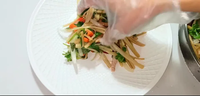 Arrange the salad on a plate, alternating layers of lotus root, shrimp, and pork. Garnish with fried onions and roasted peanuts.