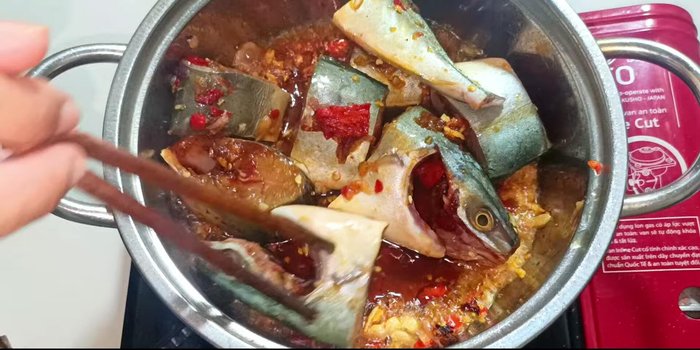 Add the marinated fish to the pot, sliding it back and forth to sear both sides.