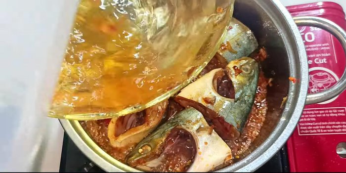 Pour in 300ml of fresh coconut water (from the fish marinade bowl). The water should just cover the fish.