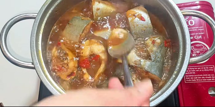Add salt to taste. Stir gently, flipping the fish to ensure even cooking and color.