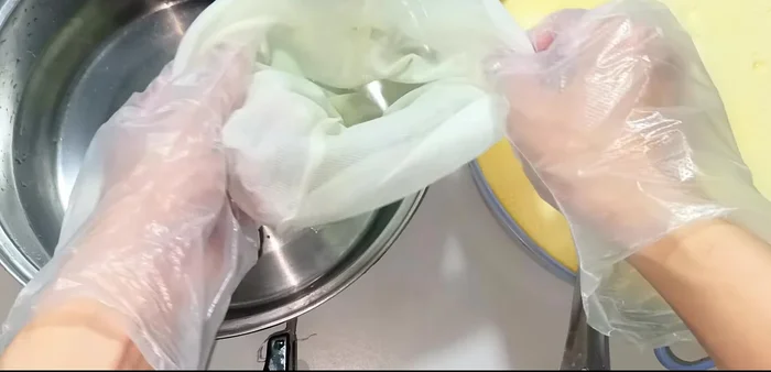 Squeeze the mixture through a cloth bag to separate the corn milk from the pulp.