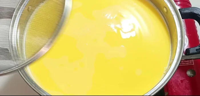 Strain the corn cob and husk liquid through a sieve into the corn milk.
