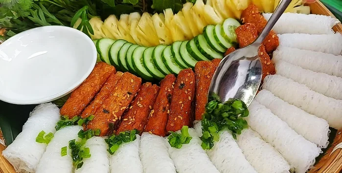 Arrange rice vermicelli, vegetables (cucumbers), and braised vegetarian ribs on a tray. Drizzle with onion oil.
