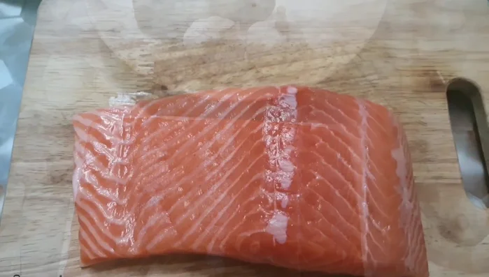 Place the salmon fillet in the pan.