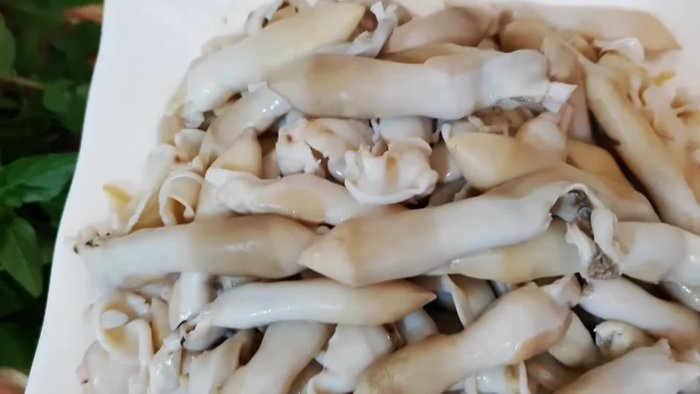 Stir-fry the cockles with basil and spices. (Details of cooking process are not provided in the transcript)