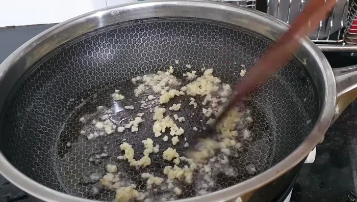 Add pineapple, tomato, and chili to the pan and stir-fry until cooked.