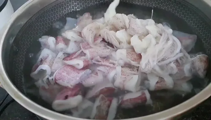 Blanch the squid in boiling water with salt and ginger for about 1 minute to remove the fishy smell. Then, immediately soak it in ice water to keep it white and crispy.