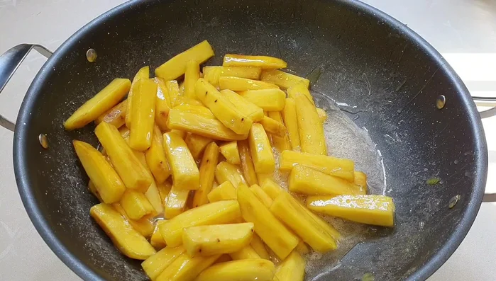 Reduce heat to the lowest setting and stir gently until the sugar is completely dry and the potatoes are coated in a layer of white powder (570.399).
