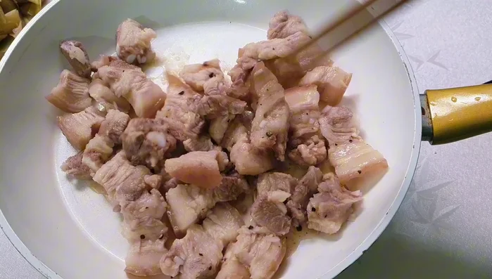 Stir-fry the marinated pork belly until firm to release fat.
