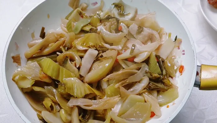 Add the stir-fried pork belly to the pickled cabbage and continue to stir-fry.