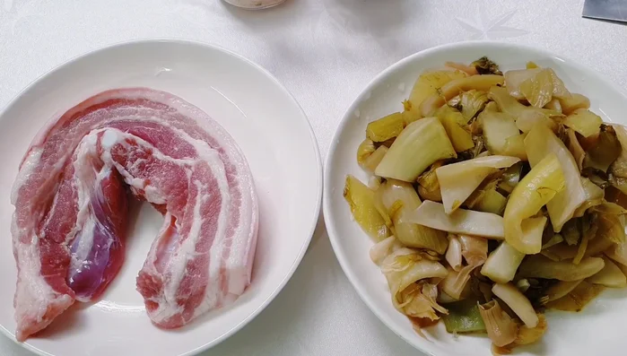 Wash pork belly with salt water, pickled cucumber, and tomato. Rinse with water to remove sourness.