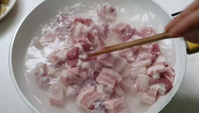 Boil pork belly in salted water, then rinse again.