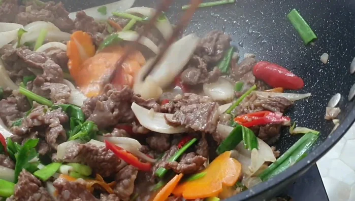 Heat oil in a wok or large frying pan over medium-high heat. (No specific instructions in transcript)