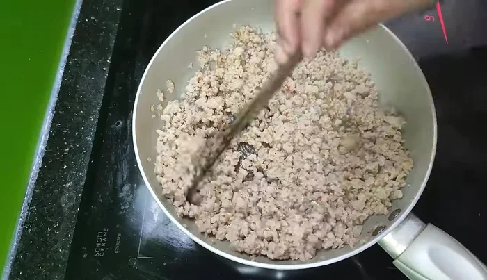 Continue stir-frying until the meat is firm and golden brown.