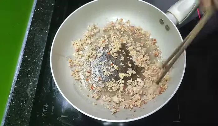 Add the minced meat and stir-fry until browned.