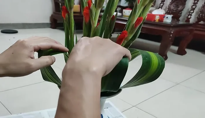 Arrange the leaves around the flowers, creating a harmonious and balanced look. Add leaves behind and in front for visual depth.