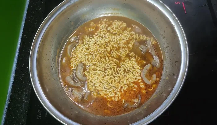 Cover the pan and let it simmer until the noodles are cooked and the meat is done.