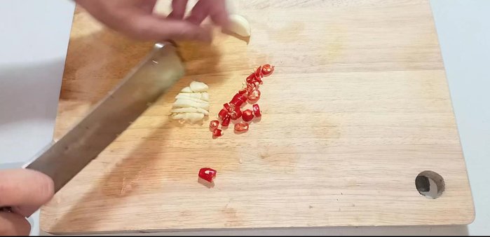 Prepare the dipping sauce: Chop chili and garlic. Mix fish sauce, sugar, lime juice, and cooled boiled water until sugar dissolves.