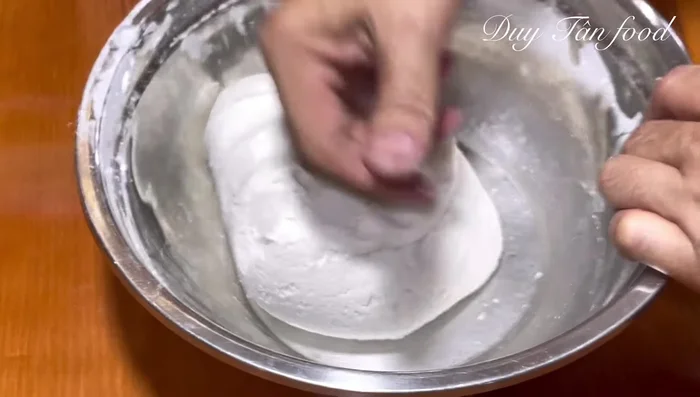 Assemble the cakes: Take a portion of dough (twice the amount of the filling). Make a hole in the center, add the filling, close the dough, and roll it into a slightly flattened ball. Ensure no air is trapped inside. (303.28)