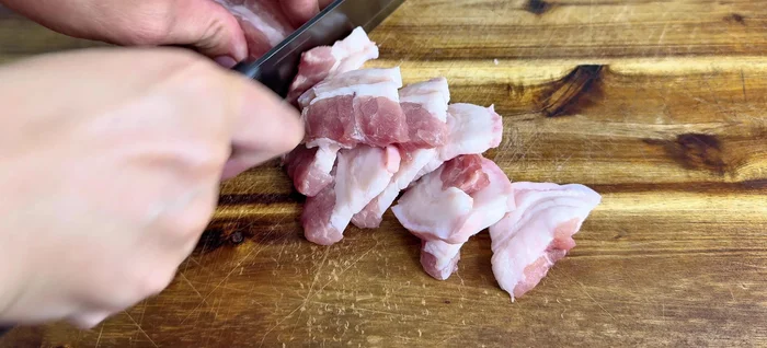 Prepare ingredients: Cut pork belly into square pieces. Grind onion, garlic, and green onion roots.